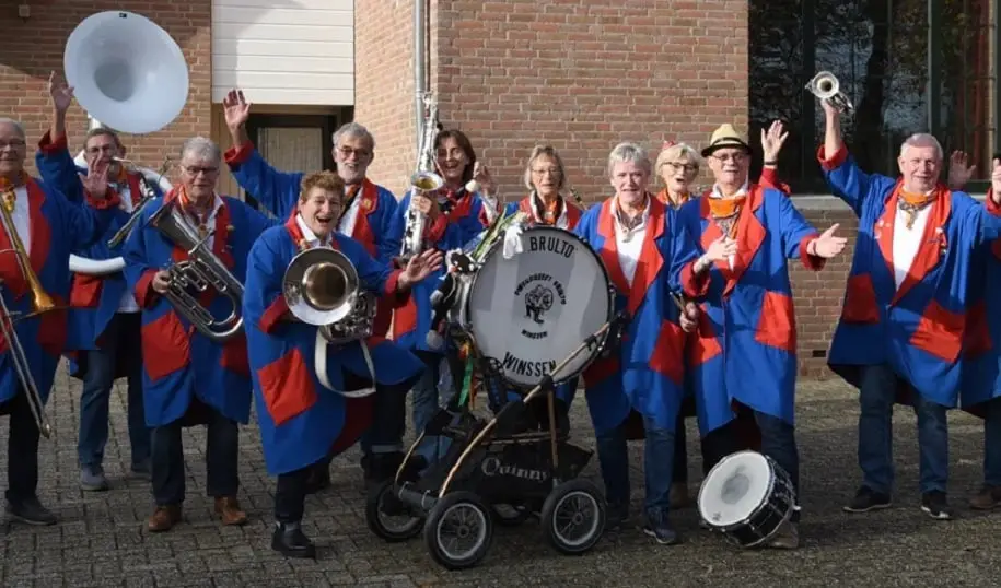 Brulto uit Winssen in blauw-rode jassen met instrumenten en de eigen grote trom